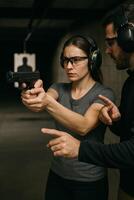 Woman Receives Firearm Training in Indoor Shooting Range for Skill Development and Safety photo