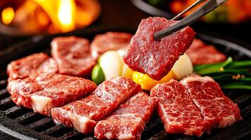 A person holding tongs over a piece of meat photo