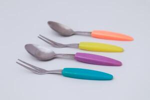 Vibrant Retro Spoons and Forks Arranged in a Colorful Row Isolated photo