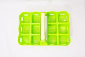 Creative Bright Green Ice Cube Tray on Clean White Backdrop for Refreshing Drinks photo