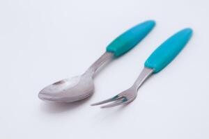 Spoon and Fork Utensils in Turquoise Handle Placed on a White Surface photo