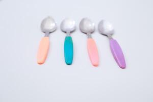 Pastel Handled Spoons Arrange over Clean Background for Soft Kitchenware Concept photo