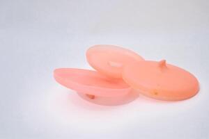 Peach Plastic Discs Isolated On White Backdrop In A Minimalist Style photo