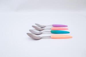 Pastel Handle Spoons Arrayed on Clean White Background, Kitchen Flatware photo