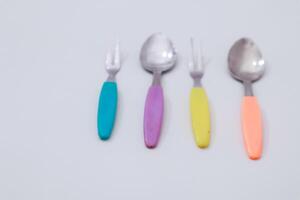 Assorted Retro Silverware with Colorful Handles on Neutral Background photo