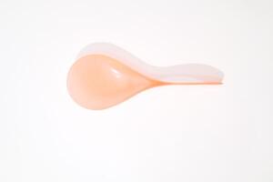 Minimalist image of an orange balloon with its shadow on a white backdrop photo