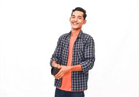 Smiling Young Man In Plaid Shirt Holding Object Against White Background photo