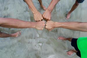 fists bump on beach, symbolizing a group achievement photo