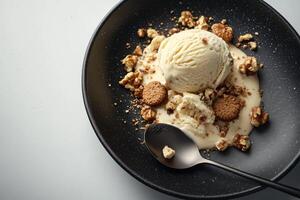 A bowl of ice cream with nuts and a spoon photo