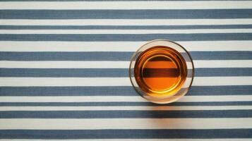 A glass of orange juice on a striped tablecloth photo