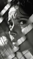 A woman is looking through a fence photo
