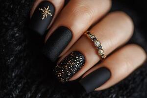 Black matte nail polish with gold glitter photo