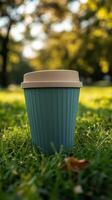 A blue cup sitting on the grass in the park photo
