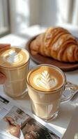 Two cups of coffee with latte art on top of a table photo