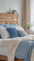 A bed with blue and white bedding and wooden headboard photo