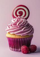 A cupcake with a pink frosting and a lollipop photo