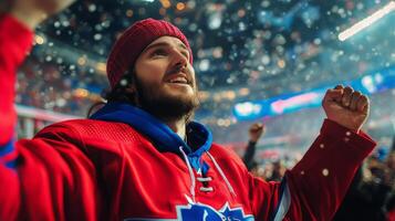 A man in a red jersey is cheering in the snow photo