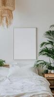A white bedroom with a bed, a lamp and a framed picture photo
