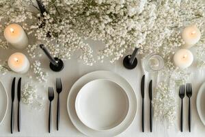 A table setting with white plates, silverware and candles photo