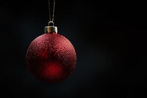 A red christmas ball hanging from a string photo