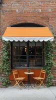 A table and chairs under an orange awning photo