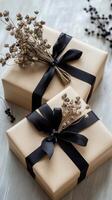 Two wrapped presents with black ribbon and dried flowers photo