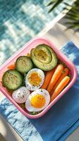 A pink container with a salad and eggs photo