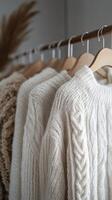 A row of white sweaters on a hanger photo