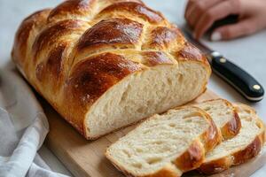 A loaf of bread on a cutting board with a knife photo