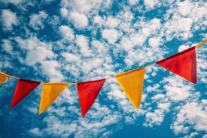 A red, yellow and white bunting with a blue sky background photo