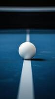A white egg sits on a blue table tennis court photo