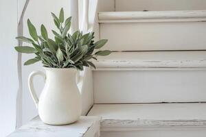 A white pitcher with a plant on a wooden staircase photo