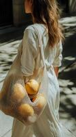 A woman carrying a mesh bag with lemons photo