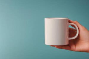A person holding a white mug on a blue background photo