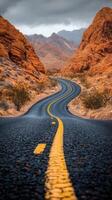 An empty road in the desert with mountains in the background photo