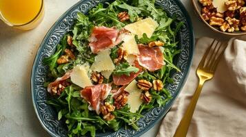 A plate of salad with prosciutto, cheese and greens photo