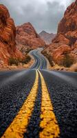 A road with yellow lines in the middle of a desert photo