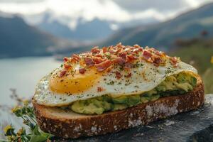 A sandwich with an egg and bacon on top of it photo