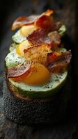 A piece of toast with eggs, bacon and avocado photo