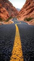 A long road with yellow lines in the middle of the desert photo