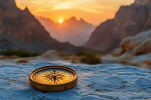 A compass on the mountain at sunset photo