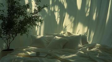 A bed with pillows and a plant in front of it photo