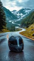 A motorcycle helmet sits on the road in front of a mountain photo