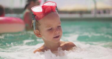 Toddler swimming in pool with red goggles video