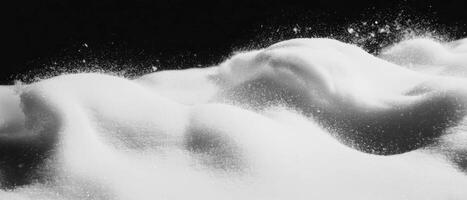 Drifting snow with swirling patterns against a black background creating a serene atmosphere photo