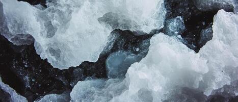 Black ink and salt crystallization create intricate textured patterns on a grainy surface photo
