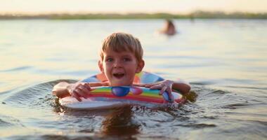 Happy child swimming with colorful float ring video