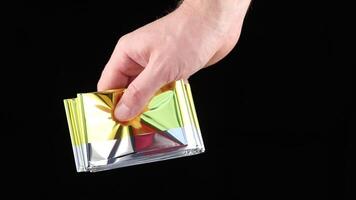A person holding a small piece of paper with a colorful design video