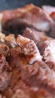 Chef slicing medium or well done beef steak with knife and fork on wooden cutting or chopping board, 4K. Concept of meat, beef steak video