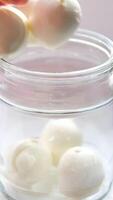 Mozzarella cheese in bowl close-up. Mozzarella is a semi-soft non-aged cheese prepared by the pasta filata method From Italian cow's milk. Mozzarella is used for most types of pizza and several pasta video